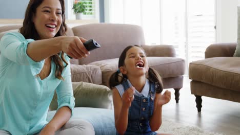 Mother-and-daughter-watching-television-in-living-room