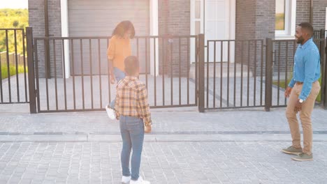 padres afroamericanos jugando al fútbol con un hijo pequeño y lindo al aire libre en casa en las afueras