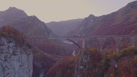 durdevica tara bridge crossing steep gorge in montenegro at sunrise, reveal shot