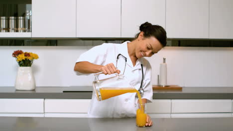 Enfermera-Casera-Sirviendo-Un-Vaso-De-Jugo-De-Naranja-En-La-Cocina