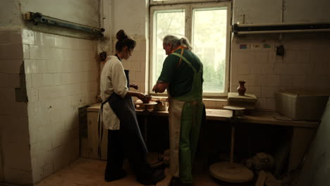 young woman making clay pot in pottery studio