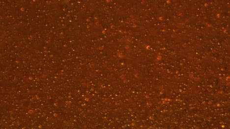 kohlendioxidblasen, die sich in der nähe des glases bewegen. kohlensäurehaltiges kaltes alkoholgetränk