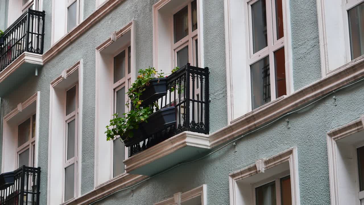 exterior de un edificio de varios pisos con balcones y flores