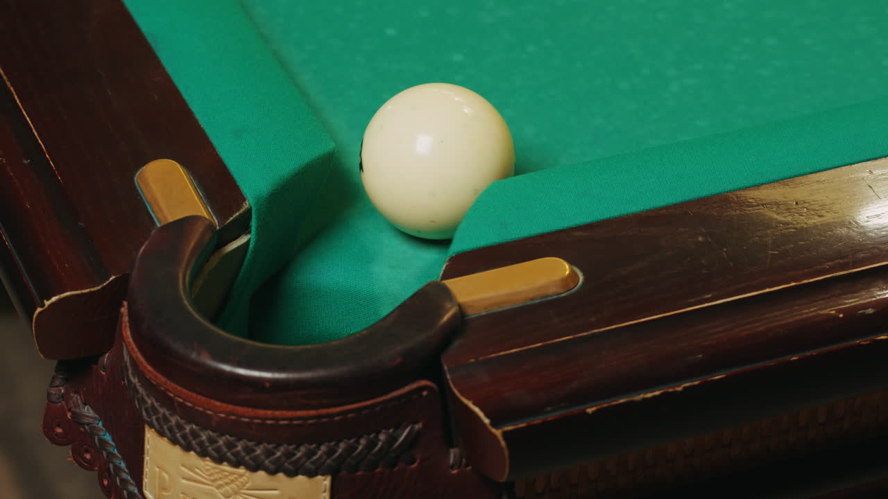 Young man breaking white pool balls with cue on green billiards table for start to play. Russian biliard game, Russian pyramid. Billiard balls with numbers on a pool table. Billiards team sport. High quality 4k footage