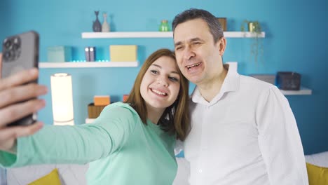 father daughter taking selfie at home.