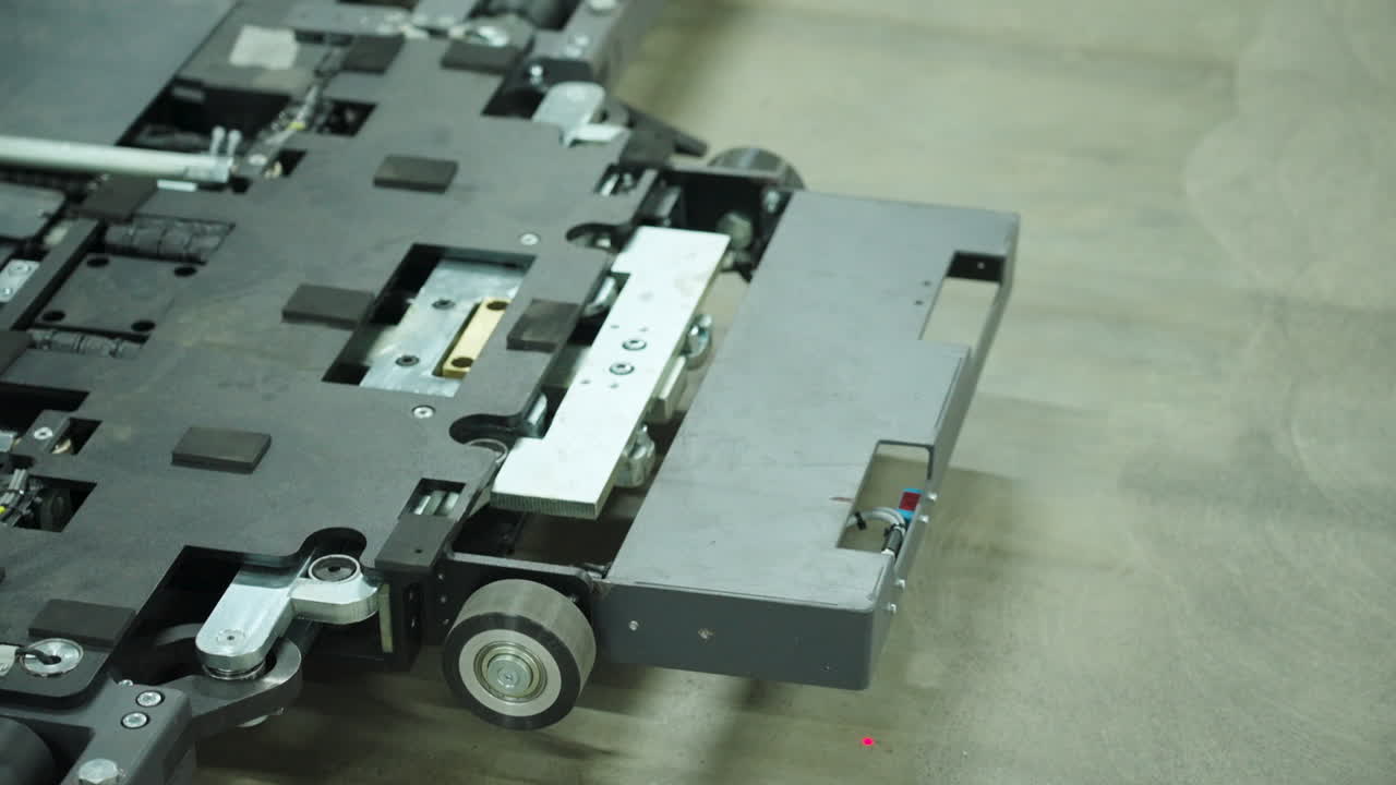 Nærbillede af en selvkørende mobilrobot, der bevæger sig hen over et fabriksgulv i Kina og viser intelligent logistik, industriel automation, transportsystemer og moderne lagerteknologi til fremstilling