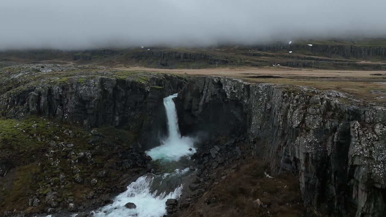 cascada folaldafoss: una toma aérea de cerca de la hermosa cascada islandesa en un día nublado