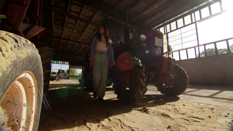 woman walking through a barn with tractors