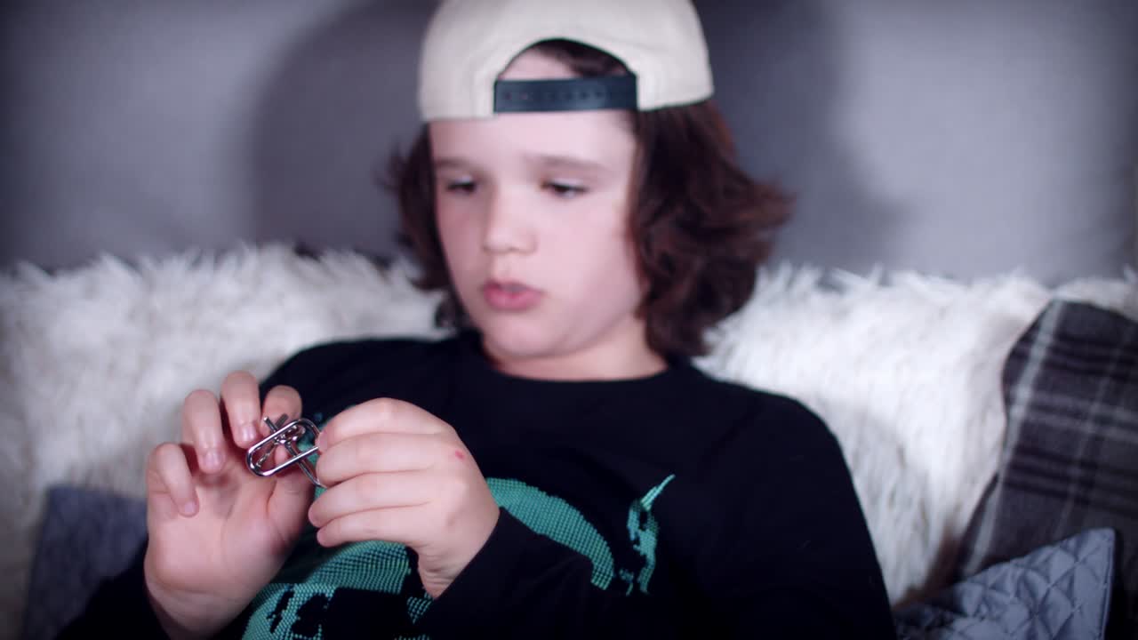 4k de manos de niños jugando con rompecabezas de metal para el cerebro teaser