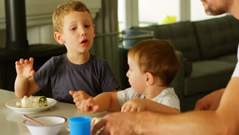 kids having food with father on dining table 4k