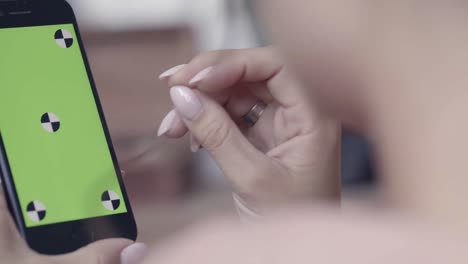 mujer usando un teléfono inteligente con una pantalla verde