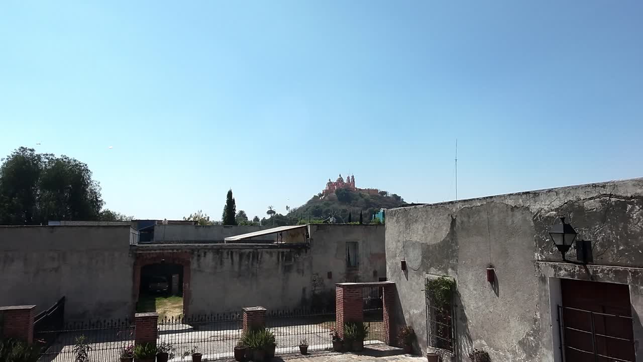 Vista soleggiata del sito di Cholula con architettura storica e cortile aperto.