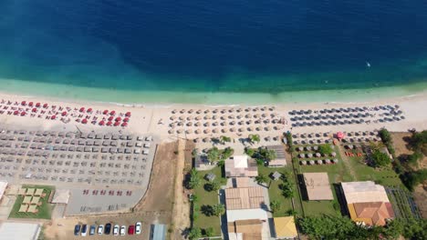 Fabulous-beautiful-magic-landscape-with-umbrellas-and-sun-beds-on-the-seafront-on-Antisamos-Beach-on-a-sunny-day-on-the-coast-of-the-Ionian-Sea-in-Kefalonia,-Greece