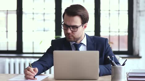 Focused male ceo executive manager managing tasks on paper checklist.
