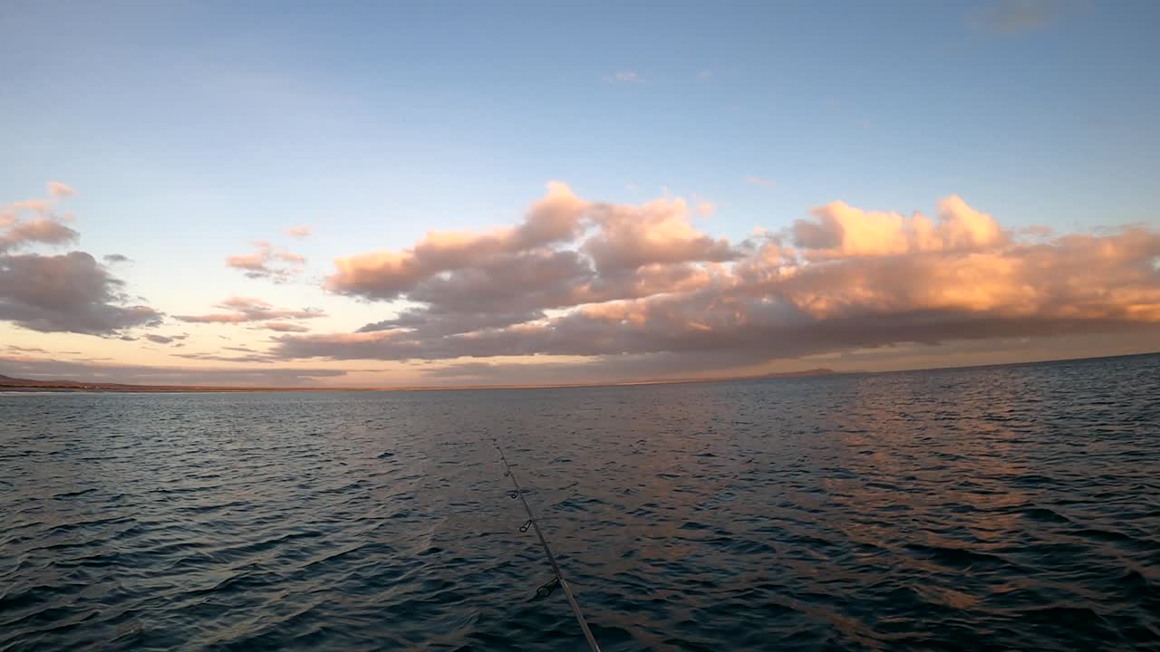 los pescadores arrojan la caña de la bobina desde el océano abierto pescando en kayak al atardecer