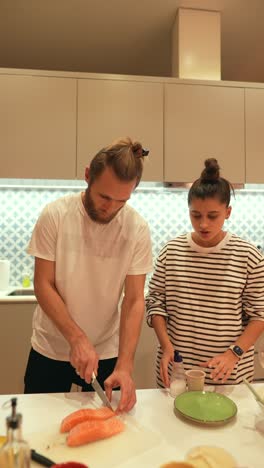 couple cooking salmon dinner