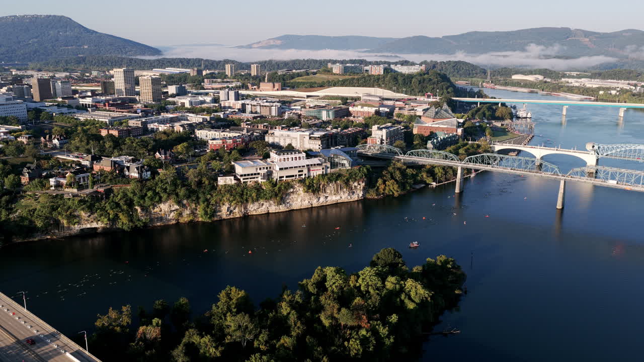 Chattanooga’s downtown skyline and river bridges frame Ironman swimmers navigating the Tennessee River on a crisp race morning
