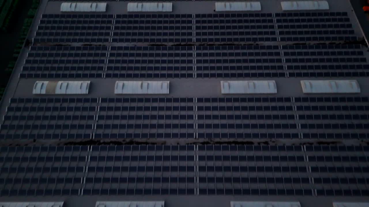 Solar Panels Farm on roof of building at night. Aerial flyover shot. Modern industrial warehouse in America producing green energy. No energy at midnight