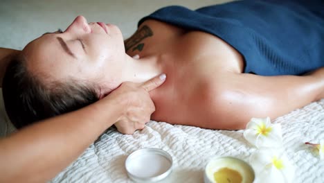 Pretty-asian-brunette-receiving-neck-massage-with-oil-at-home