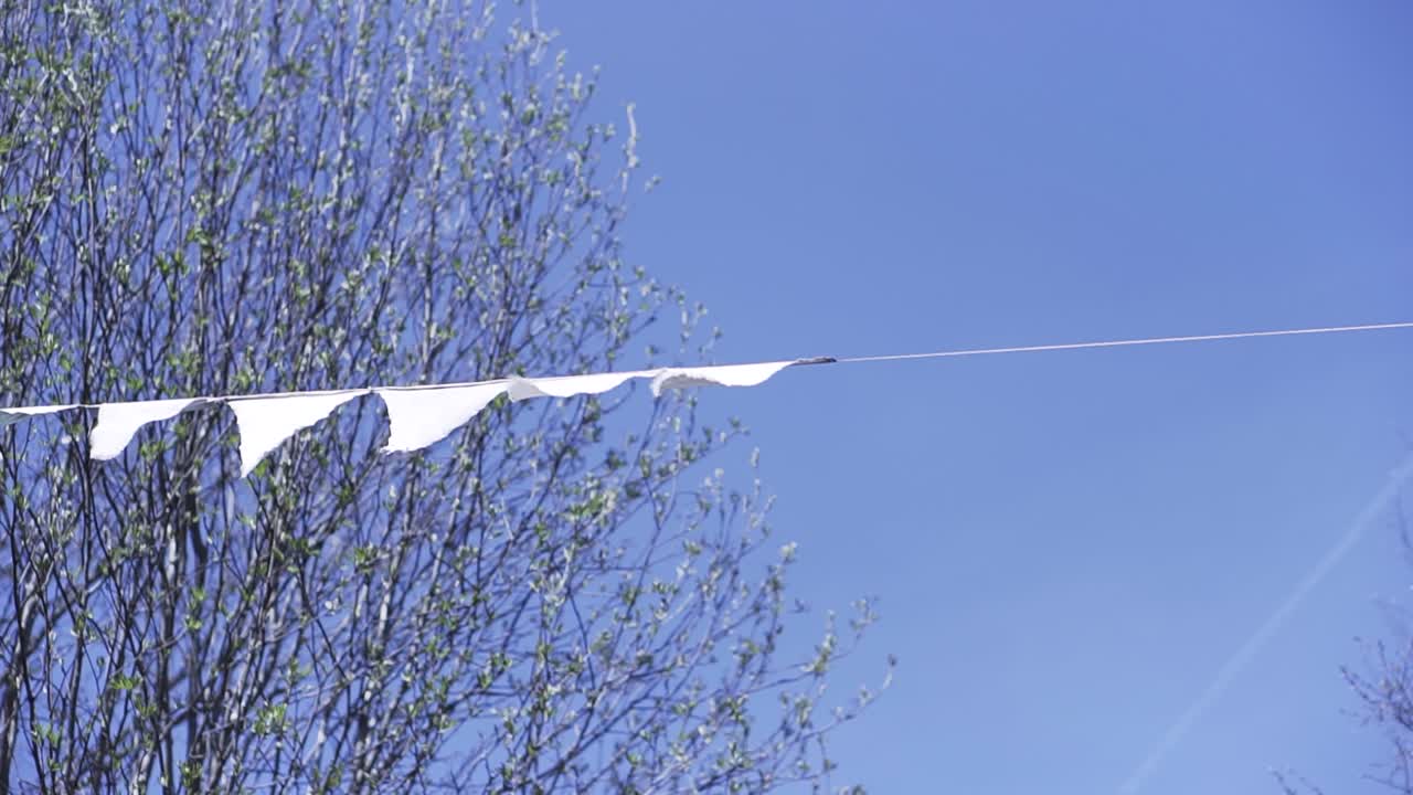 White Flags on a Line Against a Blue Sky