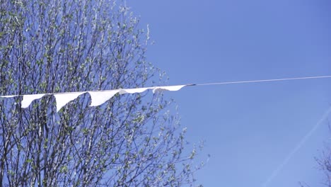 white flags on a line against a blue sky