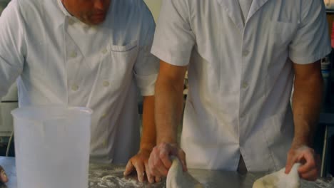 male chefs kneading flour in kitchen 4k