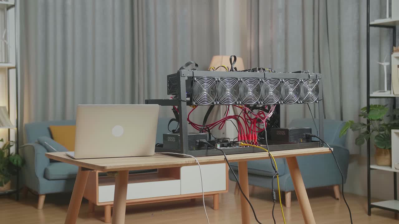 암호화폐 채굴 기기가 있는 노트북이 테이블 위에 있습니다.