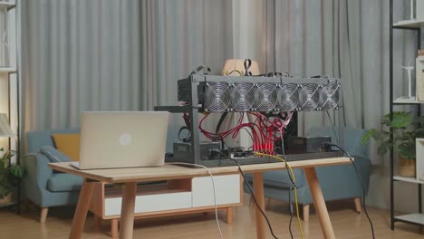a laptop is on the table with cryptocurrency mining rig