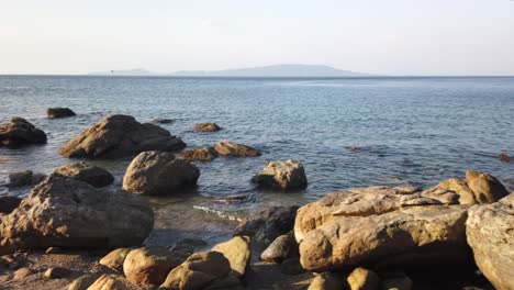 Panning-rocky-shoreline-while-walking-on-a-summer-evening,-Philippines