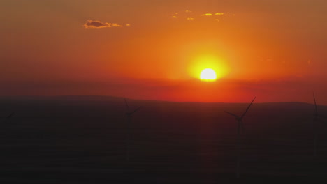 puesta de sol sobre un parque eólico