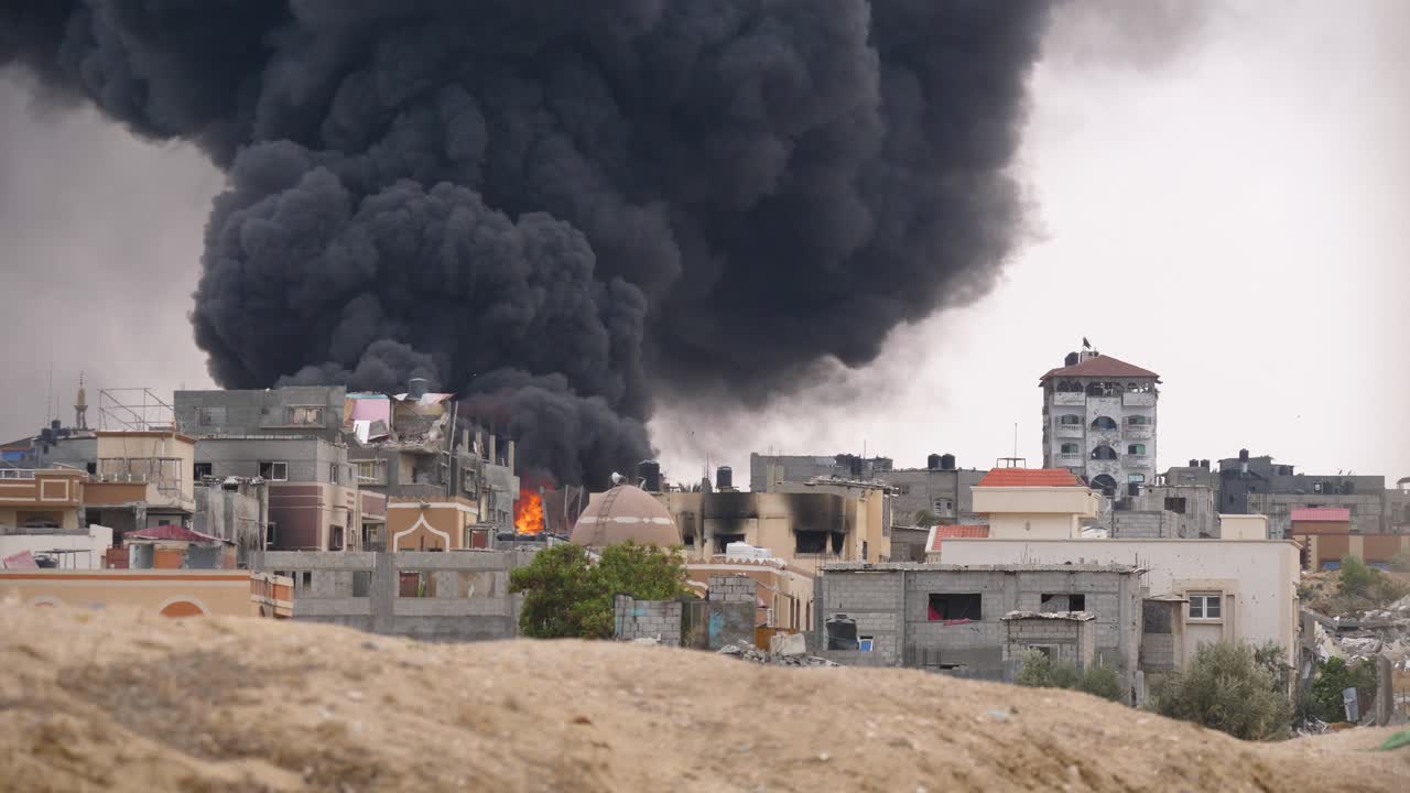 un espeso humo negro se levanta de un edificio destruido por un cohete israelí en rafah