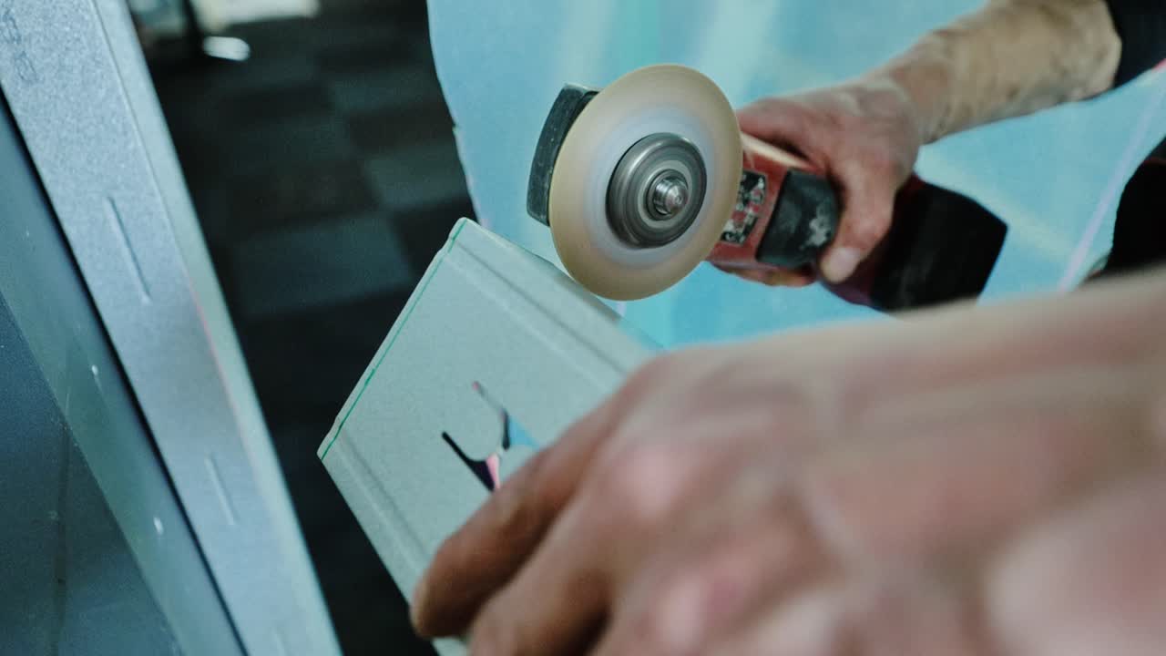 Slow motion sparks burst out from powerful grinder as craftsman cuts metal beam