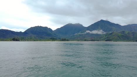 4k-Hawaii-Kauai-Bootfahren-Auf-Dem-Meer,-Das-Von-Rechts-Nach-Links-Mit-Bergen-Und-Wolken-Zum-Tal-Schwimmt