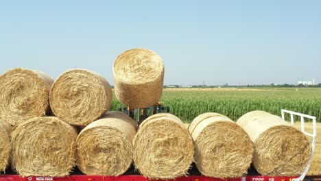 above view of agricultural field, collecting round bales of straw