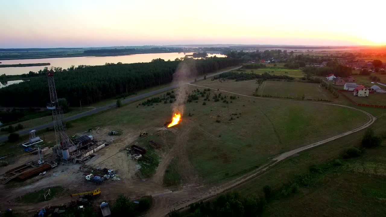 Riprese aeree della combustione di gas ad alta pressione da un pozzo di gas al tramonto