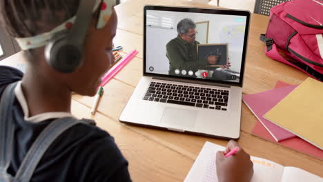 composition of african american schoolgirl on laptop online learning with male teacher