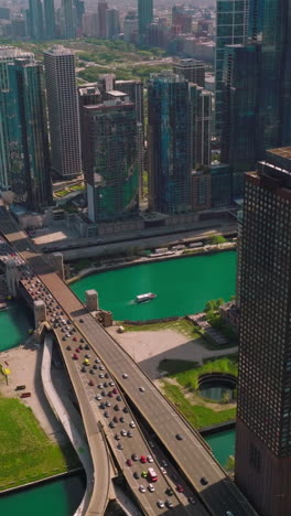 remarkable picture of sunny chicago at daytime. broad highway running through the waterfront of lake michigan. aerial view. vertical video