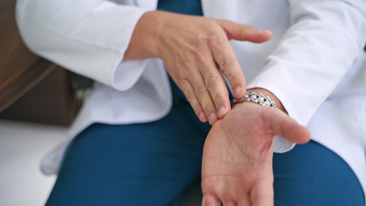 Doctor talks about the work of hand joints. Close-up specialist's hands showing the problems of arm physiotherapy. Healthcare concept.