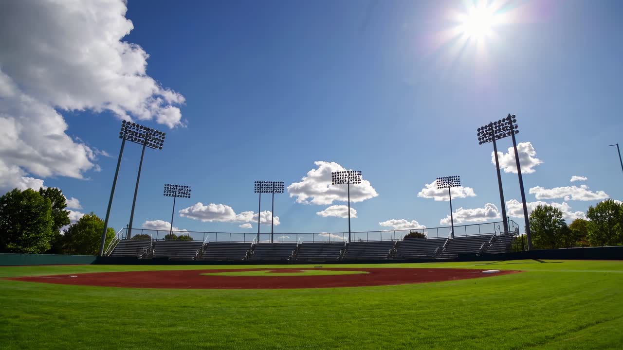 Inquadratura grandangolare di un campo da baseball vuoto sotto un cielo azzurro limpido, perfetta per un video sportivo.