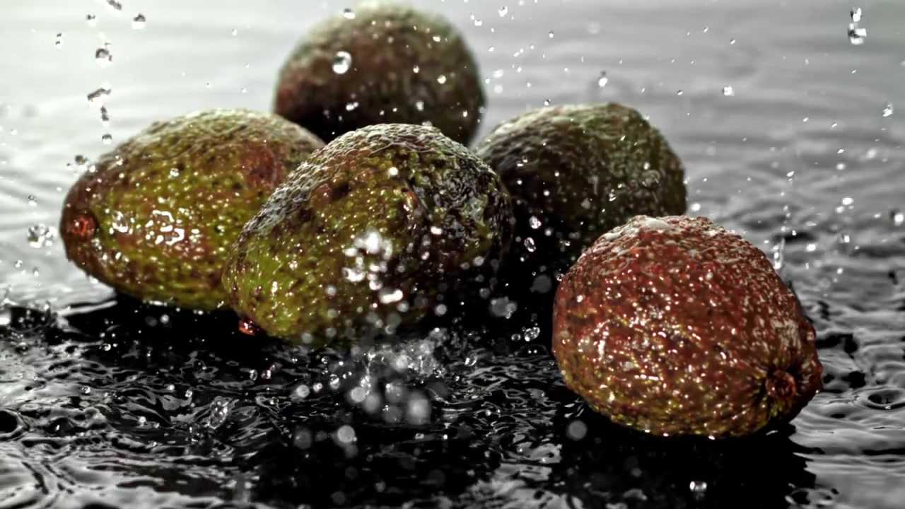Avocadi freschi con schizzi d'acqua al rallentatore