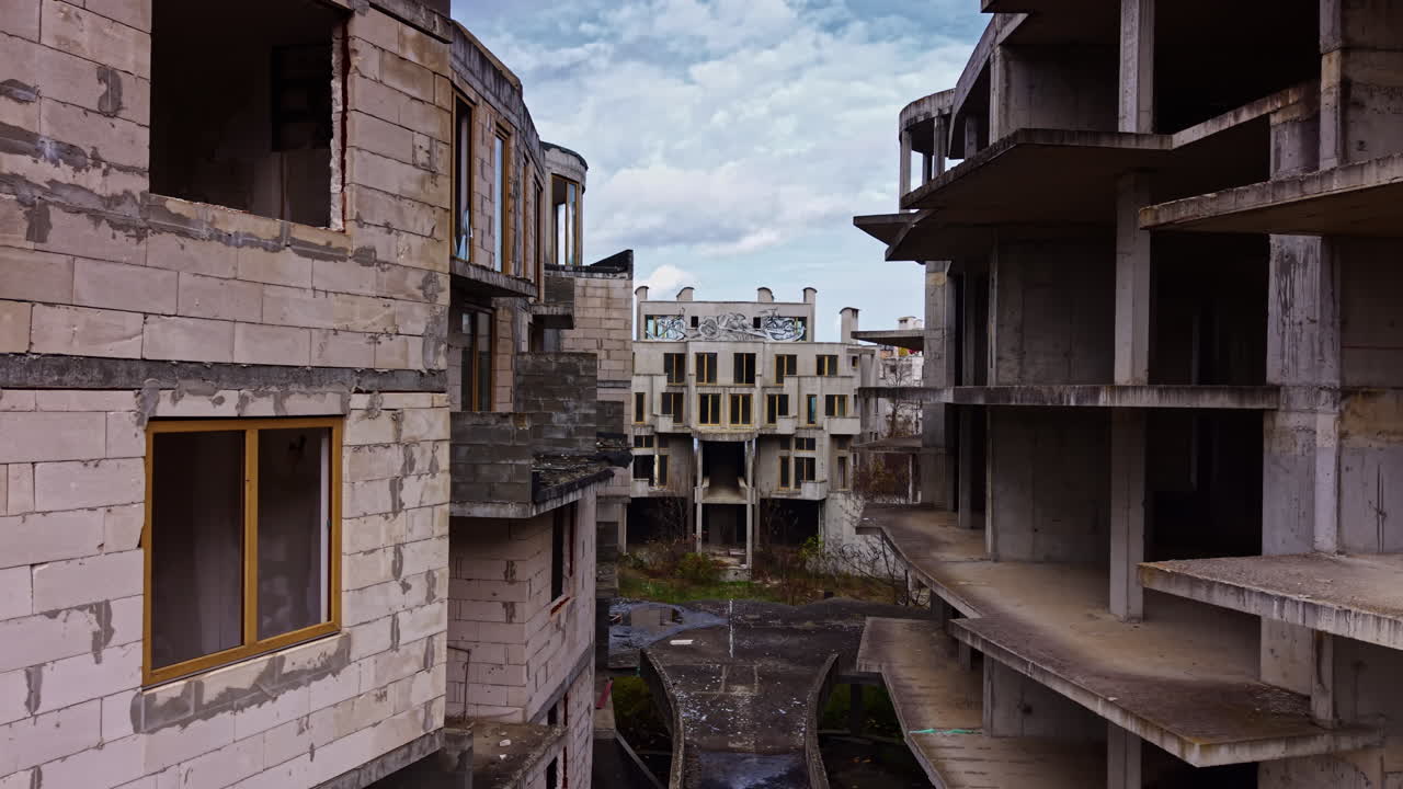 Silenziosi edifici si ergono sullo sfondo di un mare sereno, narrando storie di sogni abbandonati in una città costiera dimenticata.