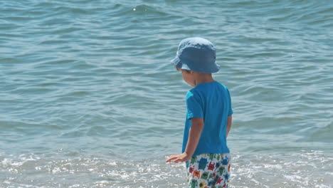little boy playing near sea
