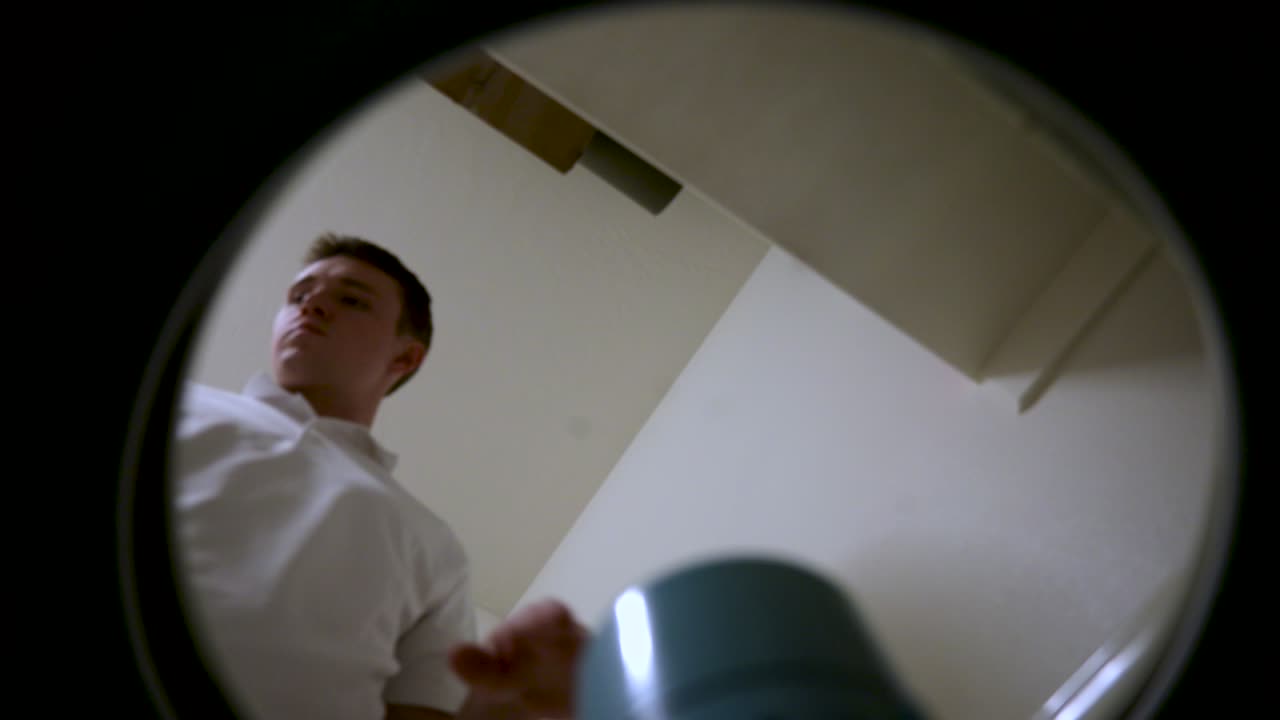 Stay-at-Home Male Homemaker Loading Dirty Laundry into Washing Machine