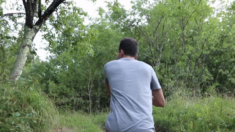 Un-Hombre-Camina-Por-Un-Sendero-En-El-Bosque,-Durante-El-Día,-Temporada-De-Verano