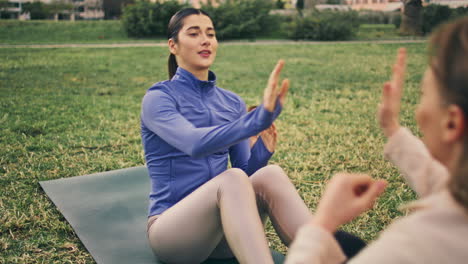 mujeres de fitness abdominales golpeando las manos juntas. amigas ejercicio de sentarse