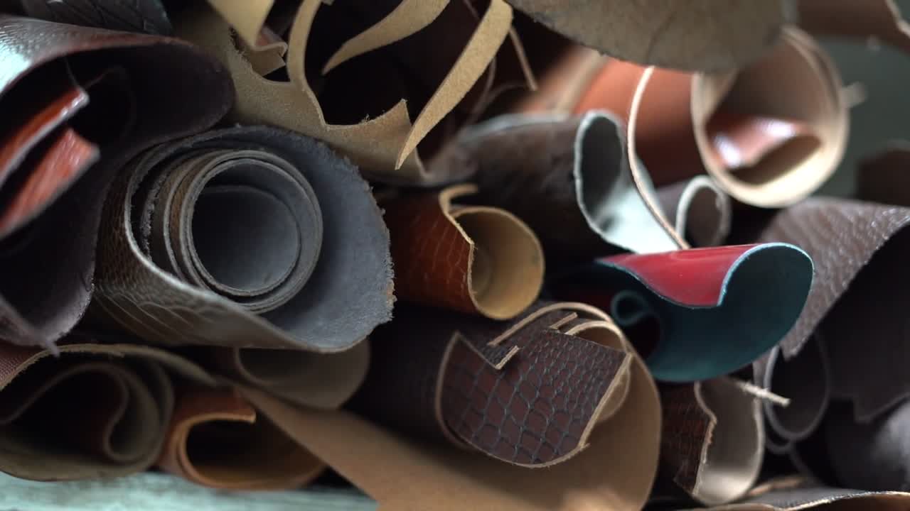 Rolled pieces of leather in different colors and textures, close up shot