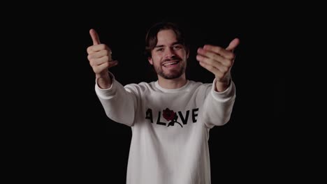 trendy young man welcoming camera, waving gesture, wide, black background