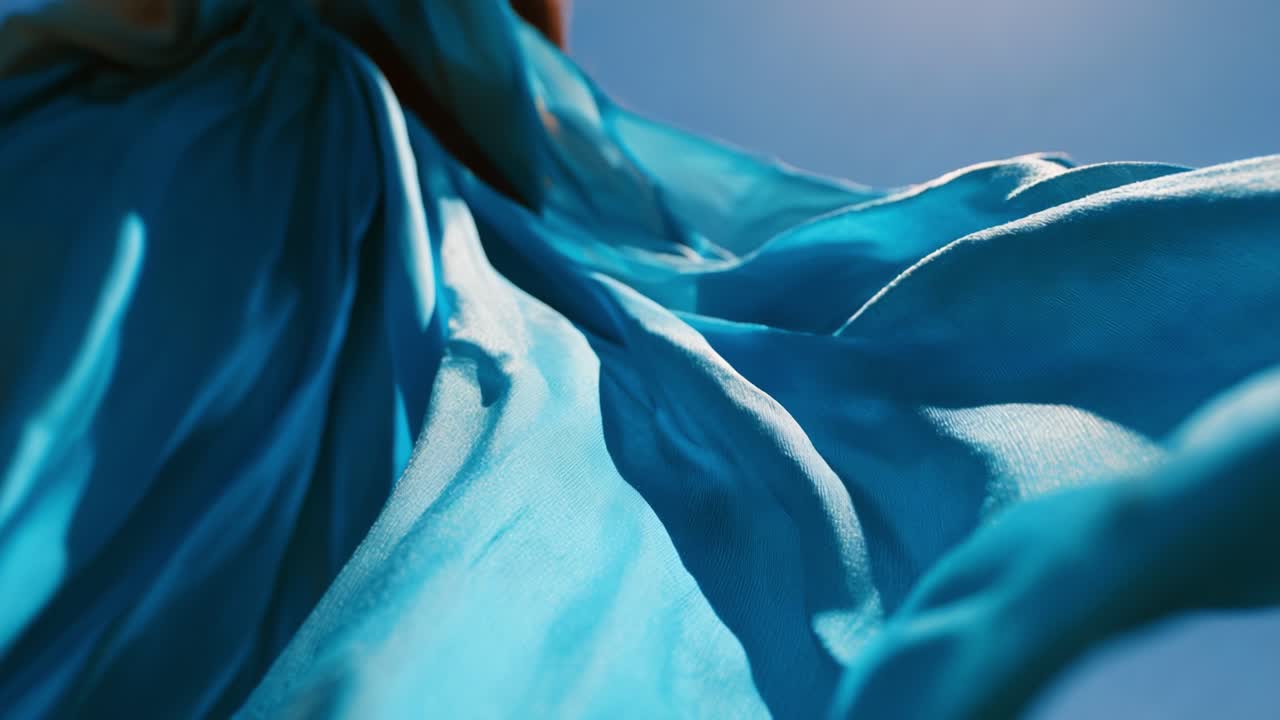 A Flowing Fabric Movement Captured in Bright Sunlight, Showcasing the Gracefulness of Light Blue Material as It Dances Through the Air, Creating a Serene and Tranquil Visual Experience in Nature