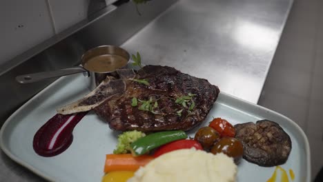 chef serving grilled pork meat with rice and vegetables, restaurant kitchen