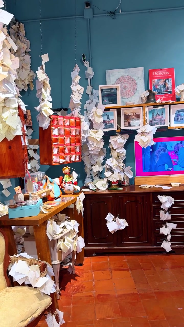 Madrid, Spain, 8 August 2025: Interior of wishing room with blue wall and paper notes. Interior view of a room with blue walls covered in numerous white paper notes and wishes on furniture.